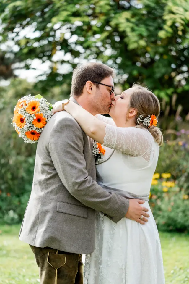 Braut Sabrina umarmt Bräutigam Markus mit Brautstrauß - Martin Schinnerl Fotografie