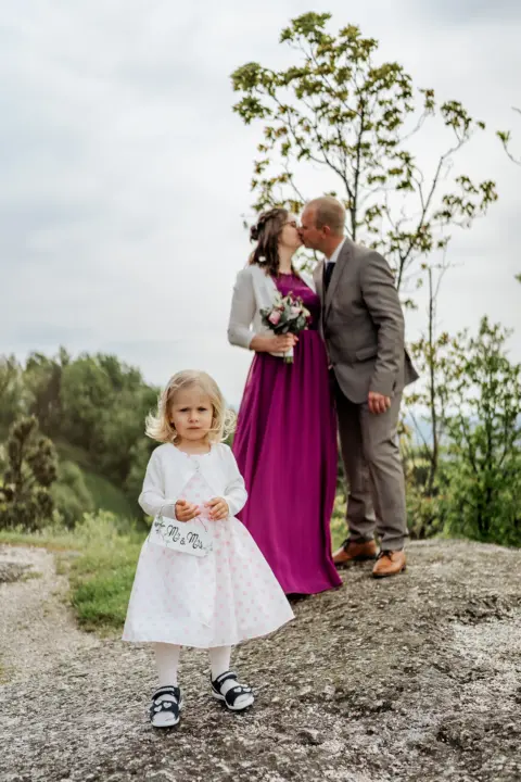 Elisabeth und Franz küssen sich hinter ihrer Tochter - Martin Schinnerl Fotografie