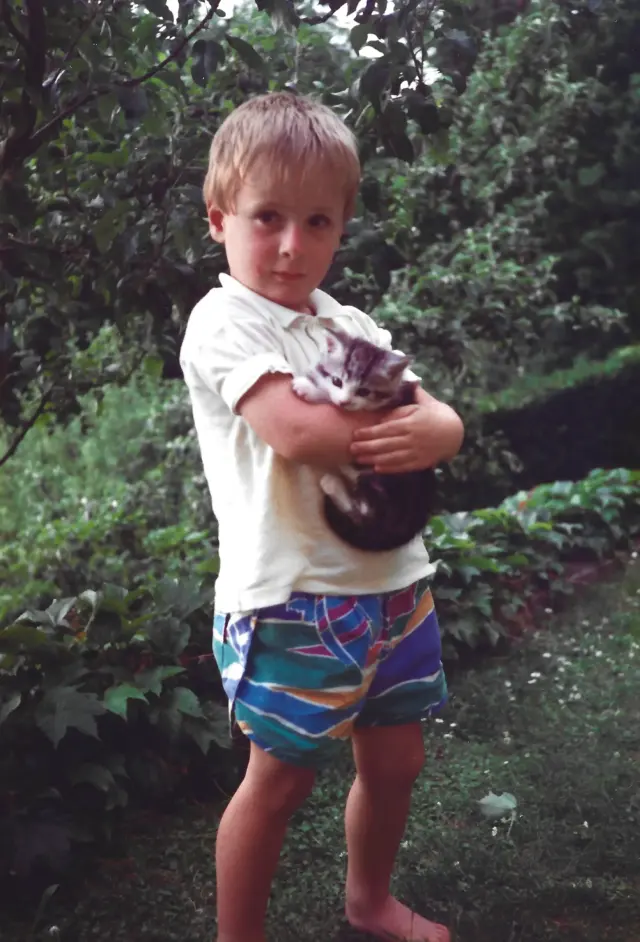 Fotograf Martin Schinnerl als Kind im Garten mit einer Katze - Martin Schinnerl Fotografie