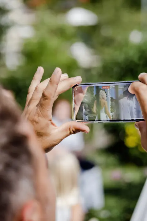 Gast filmt mit Smartphone die Hochzeit von Katrin und Mario - Martin Schinnerl Fotografie