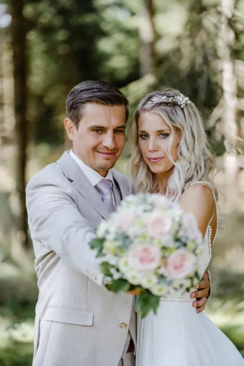 Katrin und Mario halten zusammen den Brautstrauß - Martin Schinnerl Fotografie