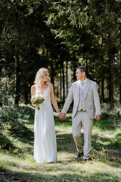 Katrin und Mario lächen sich beim Spazieren durch den Wald an - Martin Schinnerl Fotografie