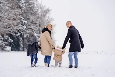 Familie stapft über die frisch verschneite Wiese - Martin Schinnerl Fotografie