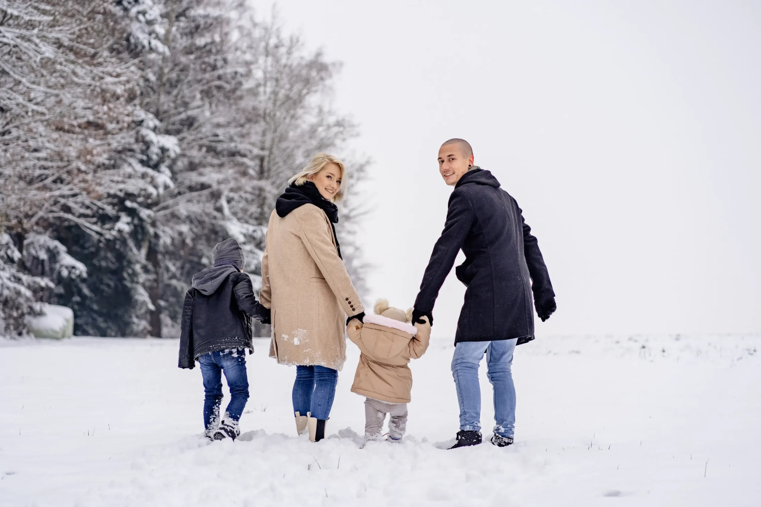 Familie stapft über die frisch verschneite Wiese - Martin Schinnerl Fotografie