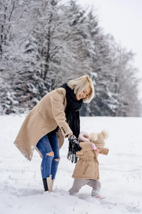 Katharina stapft mit ihrer kleinen Tochter durch den Schnee - Martin Schinnerl Fotografie