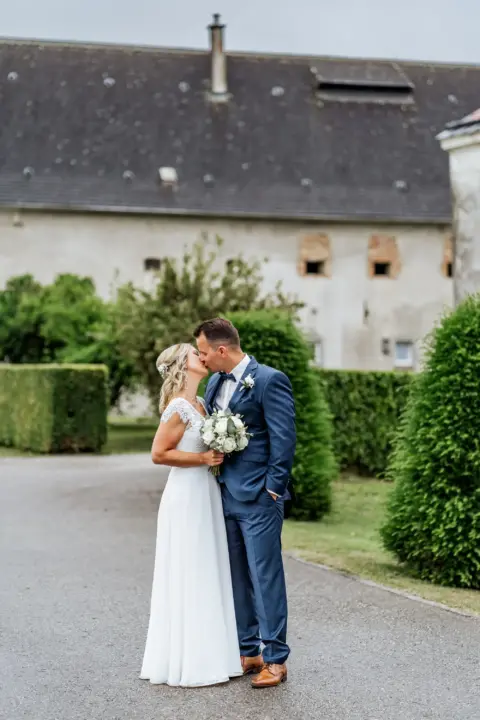 Petra und Gerhard küssen sich im Garten von Schloss Wallsee - Martin Schinnerl Fotografie
