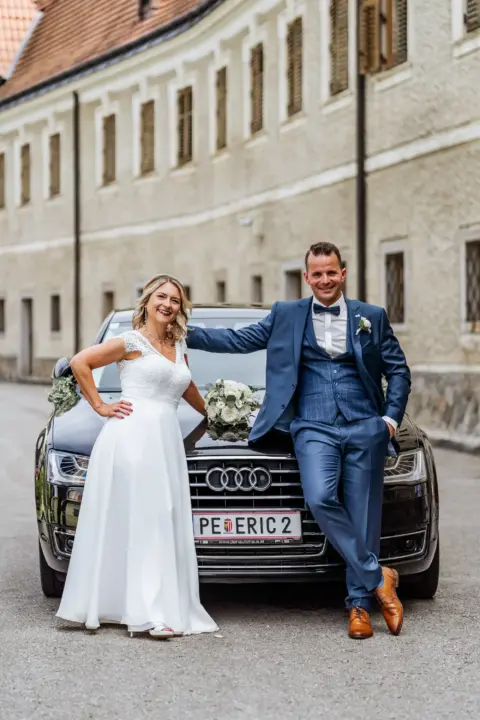 Petra und Gerhard sitzen am Brautauto - Martin Schinnerl Fotografie