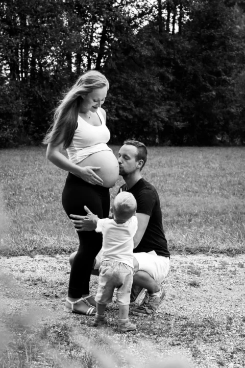 Stolzer Vater küsst Babybauch seiner Frau - Martin Schinnerl Fotografie