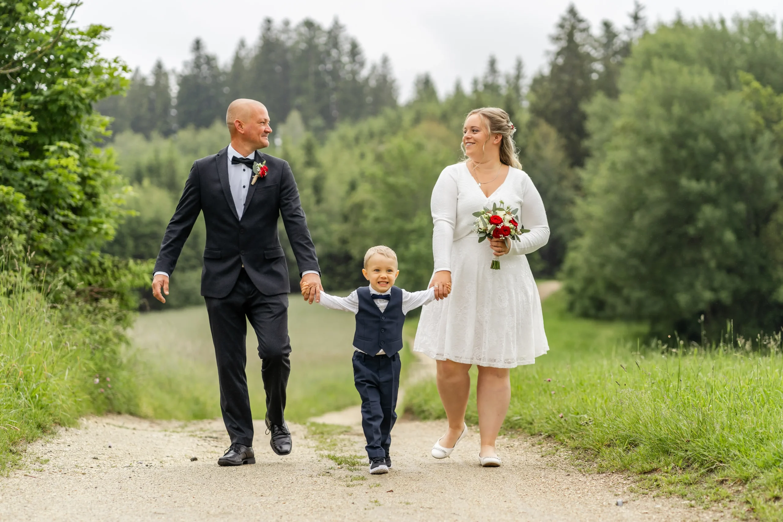Daniela und Georg spazieren vor der standesamtlichen Trauung in Pabneukirchen mit ihrem Sohn am Waldweg - Martin Schinnerl Fotografie