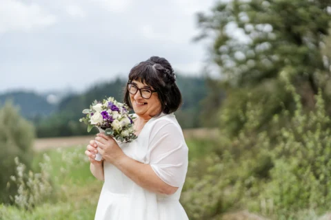 Braut Sabine strahlt vor Glück mit dem Brautstrauß in der Hand - Martin Schinnerl Fotografie