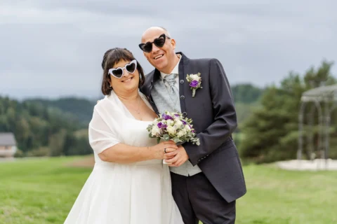 Sabine und Dietmar mit Herzerl-Brillen und Brautstrauß - Martin Schinnerl Fotografie