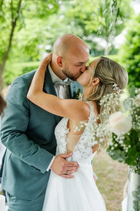 Das Brautpaar küsst sich nach der Trauung beim Wirt am Teich in St. Valentin - Martin Schinnerl Fotografie.webp