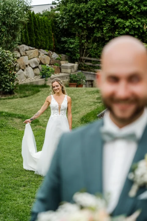 Die Braut nähert sich beim First Look langsam dem aufgeregten Bräutigam - Martin Schinnerl Fotografie