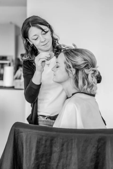 Die Braut wird von der Stylistin geschminkt beim Getting Ready zuhause in Mauthausen - Martin Schinnerl Fotografie.webp