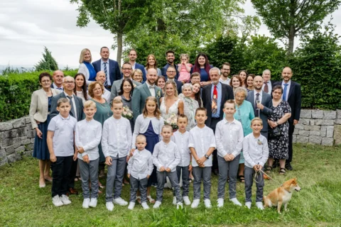 Gruppenfoto mit den Hochzeitsgästen nach der Trauung in St. Valentin - Martin Schinnerl Fotografie.webp
