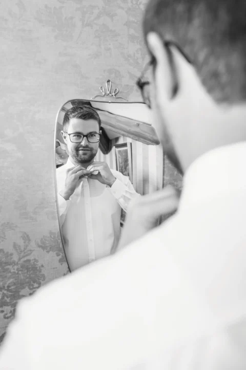 Bräutigam bindet Krawatte im Spiegel während Hochzeitsvorbereitung - Martin Schinnerl Fotografie