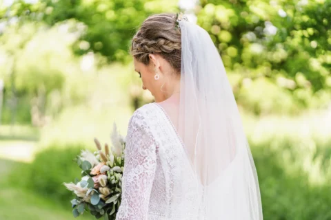 Braut mit Blumenstrauß im Garten des Vedahofs bei der Hochzeit - Martin Schinnerl Fotografie