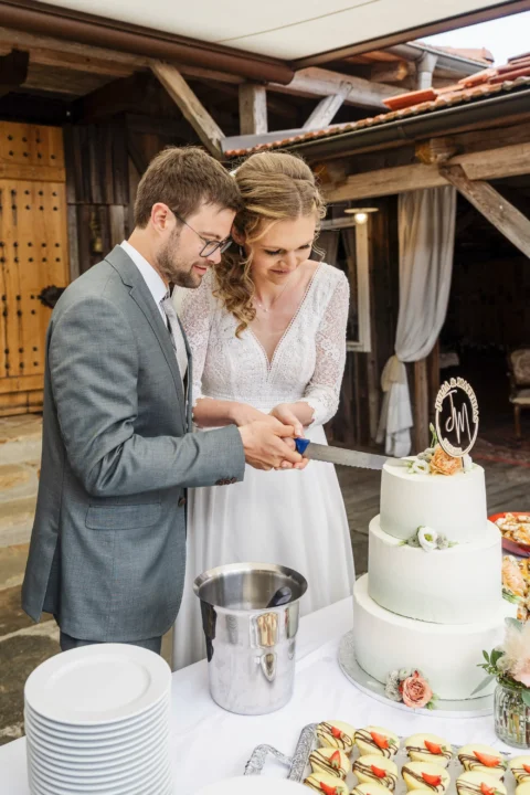 Brautpaar schneidet gemeinsam die Hochzeitstorte im Vedahof an - Martin Schinnerl Fotografie