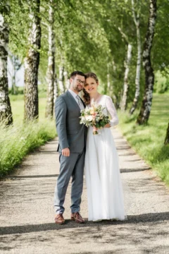 Brautpaar spaziert auf einer Allee beim Vedahof bei der Hochzeit im Mai - Martin Schinnerl Fotografie
