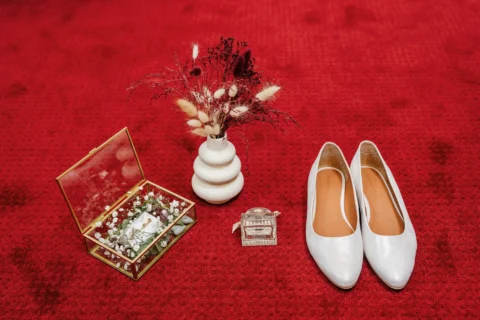 Hochzeitsschuhe und Accessoires der Braut auf rotem Teppich - Martin Schinnerl Fotografie