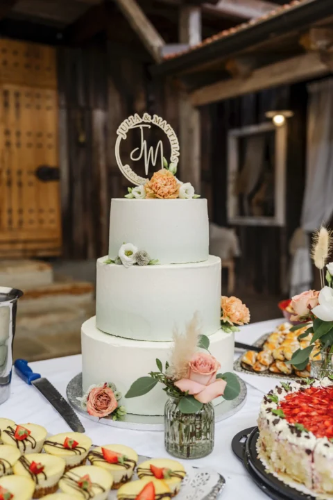 Hochzeitstorte dreistöckig mit Blumendekoration und Tortenaufsatz - Martin Schinnerl Fotografie